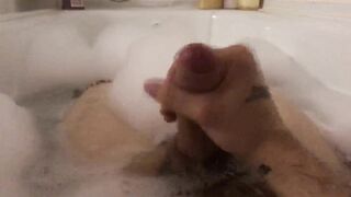 The stud jacks off taking a tub with foam