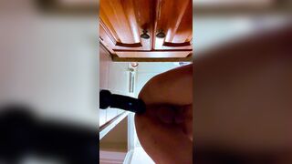 Latino dude toying with fake penises in the bathroom